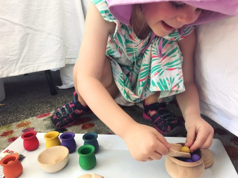 Child playing with age-appropriate wooden toys