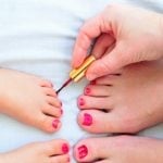 Mother and daughter painting toenails concerned with avoiding endocrine disruptors
