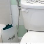 Bathroom toilet with cloth diaper sprayer attached and splatter shield