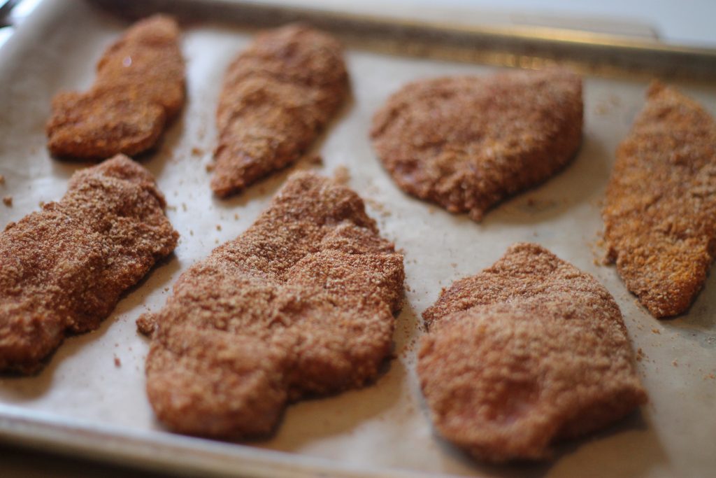 Baked chicken nuggets on a sheet pan.