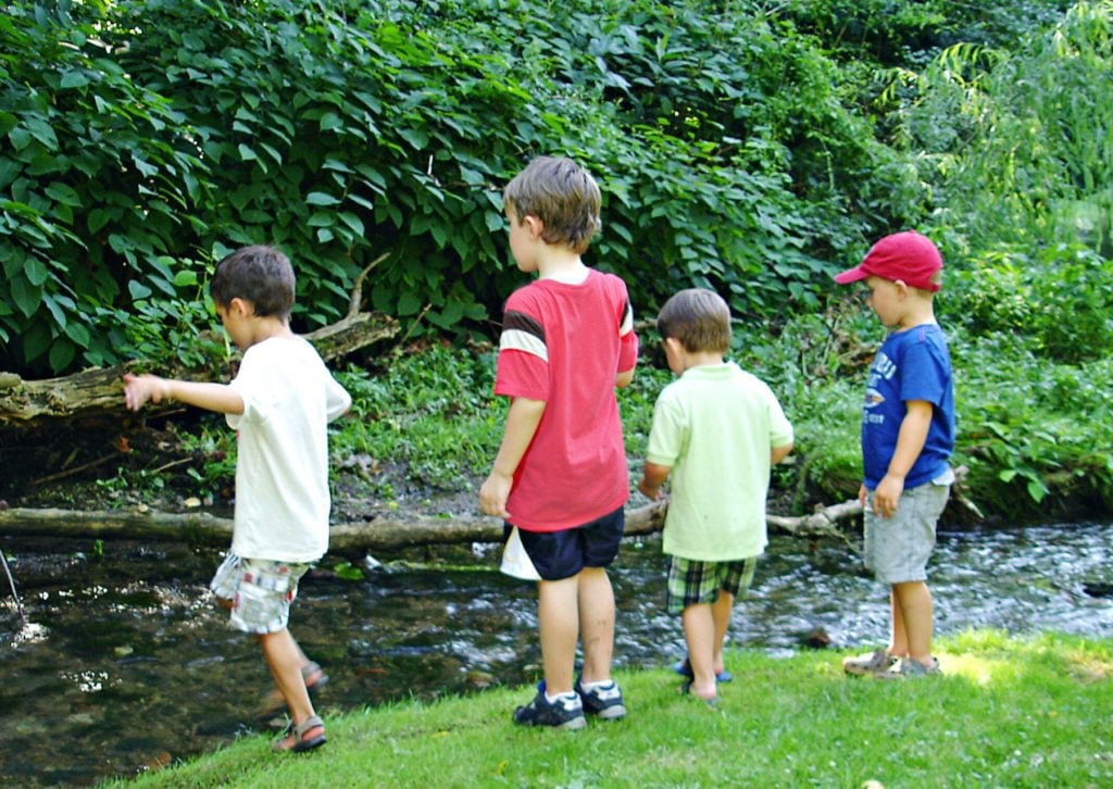 Kids playing near a stream Green Child Magazine photograph