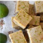 Stacked gluten free cashew lime bars with limes