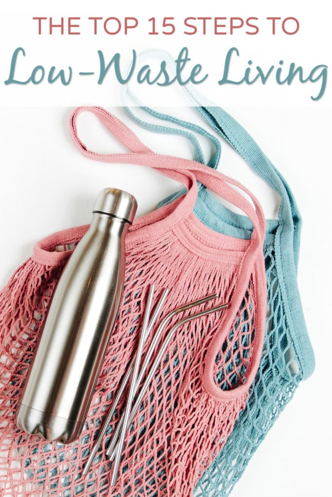 Reusable mesh bags, water bottle, and stainless steel straws on white background