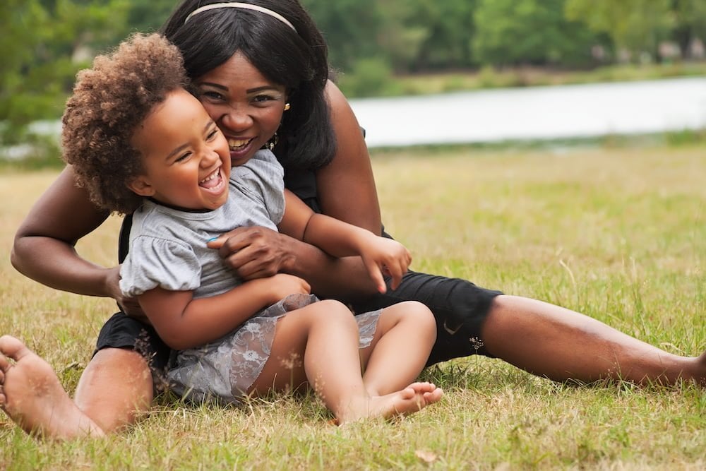 Mom hugging young daughter outside