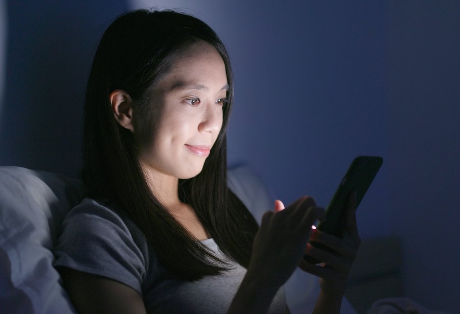 New mom in bed with phone shopping on the internet at night
