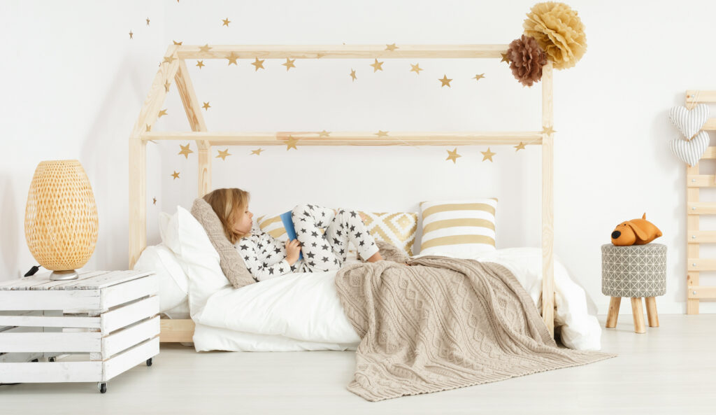 child reading in a Montessori floor bed