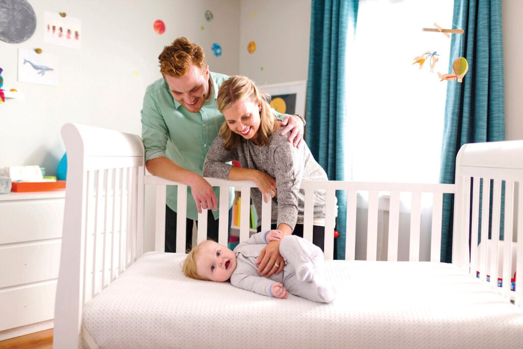 parents with baby in nontoxic crib mattress from Lullaby Earth